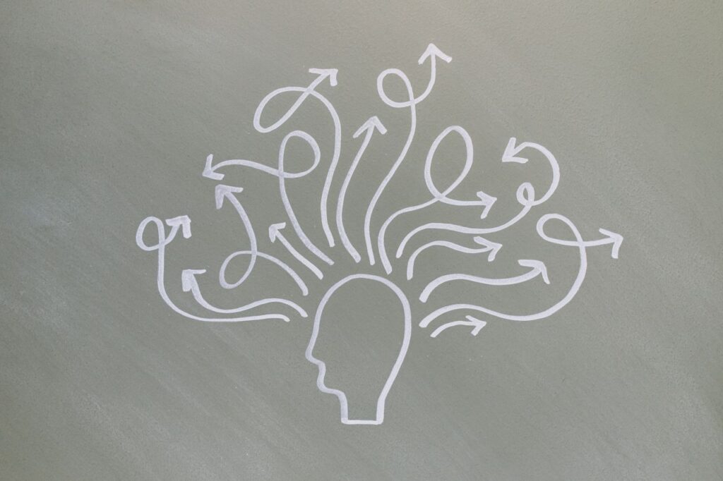 Conceptual chalk drawing illustrating mental health challenges with arrows representing thoughts.